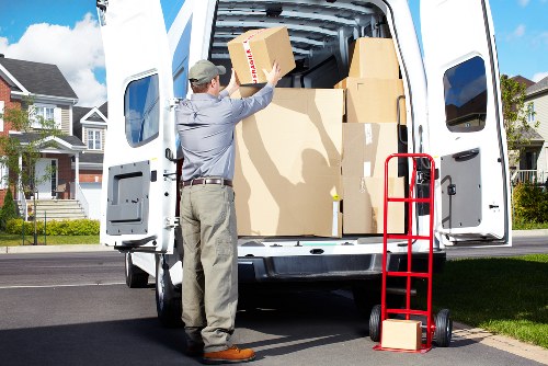Professional movers carrying furniture near a local home in Morden Park